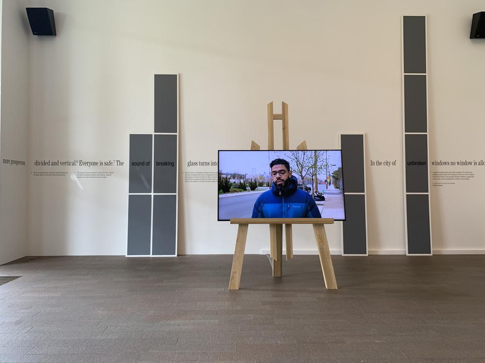tv monitor with video displayed on easel in a gallery of works