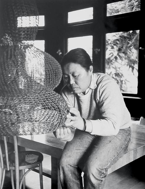 Ruth Asawa works on a looped-wire sculpture in her living room, ca. 1976.