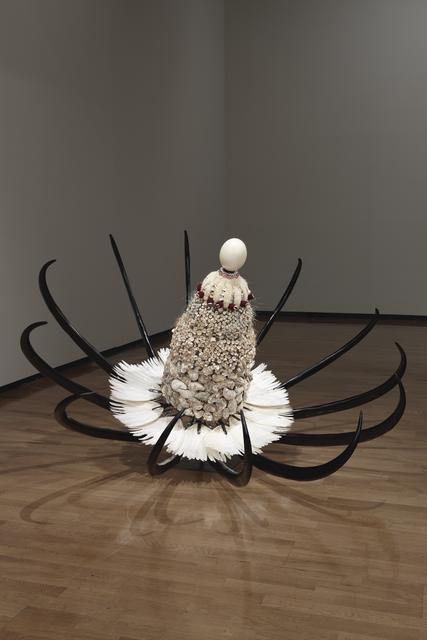 Rina Banerjee, *Winter’s Flower—Raw materials from sea and from foul and even from some exotic mice was eaten by a world hungry for commerce made these into flower, disguised could be savoured alongside whitened rice*, 2010. Oyster shells, fishbone, thread, cowrie shells, fur, deity eyes, copper trim, ostrich egg, American buffalo horns, steel, pigeon feather fans on fabricated umbrella structure and steel stand, 21 5/8 x 61 x 78 3/8 inches.