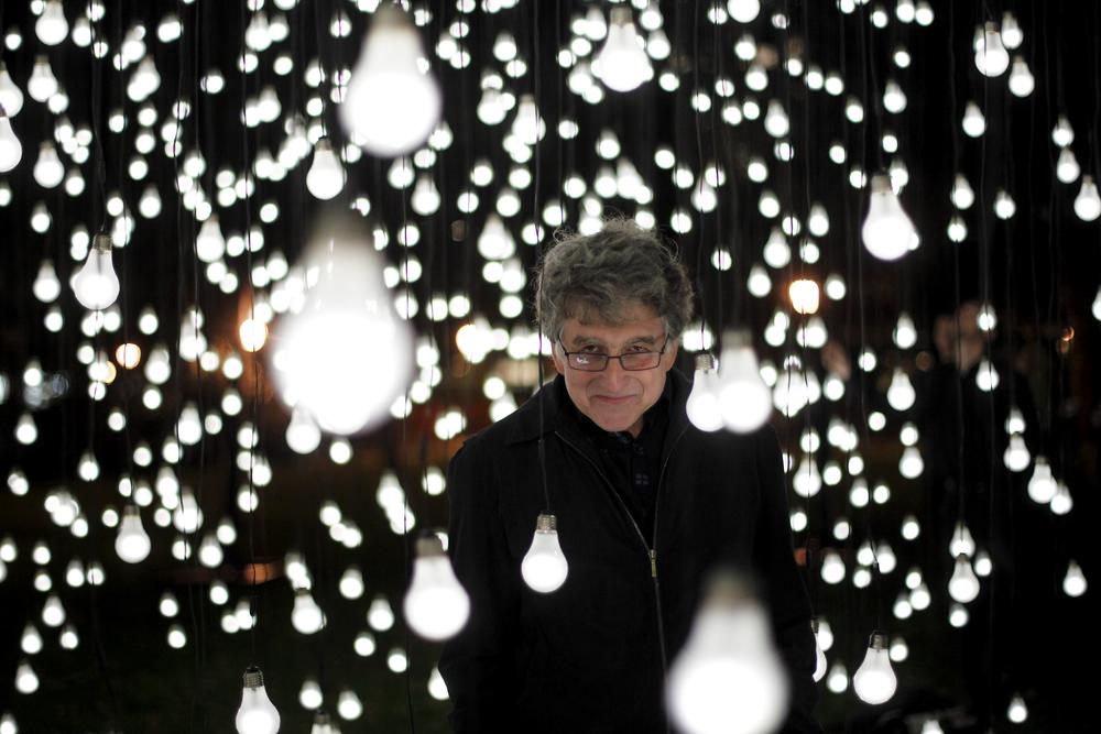 Campbell standing in an immersive installation of hanging lightbulbs