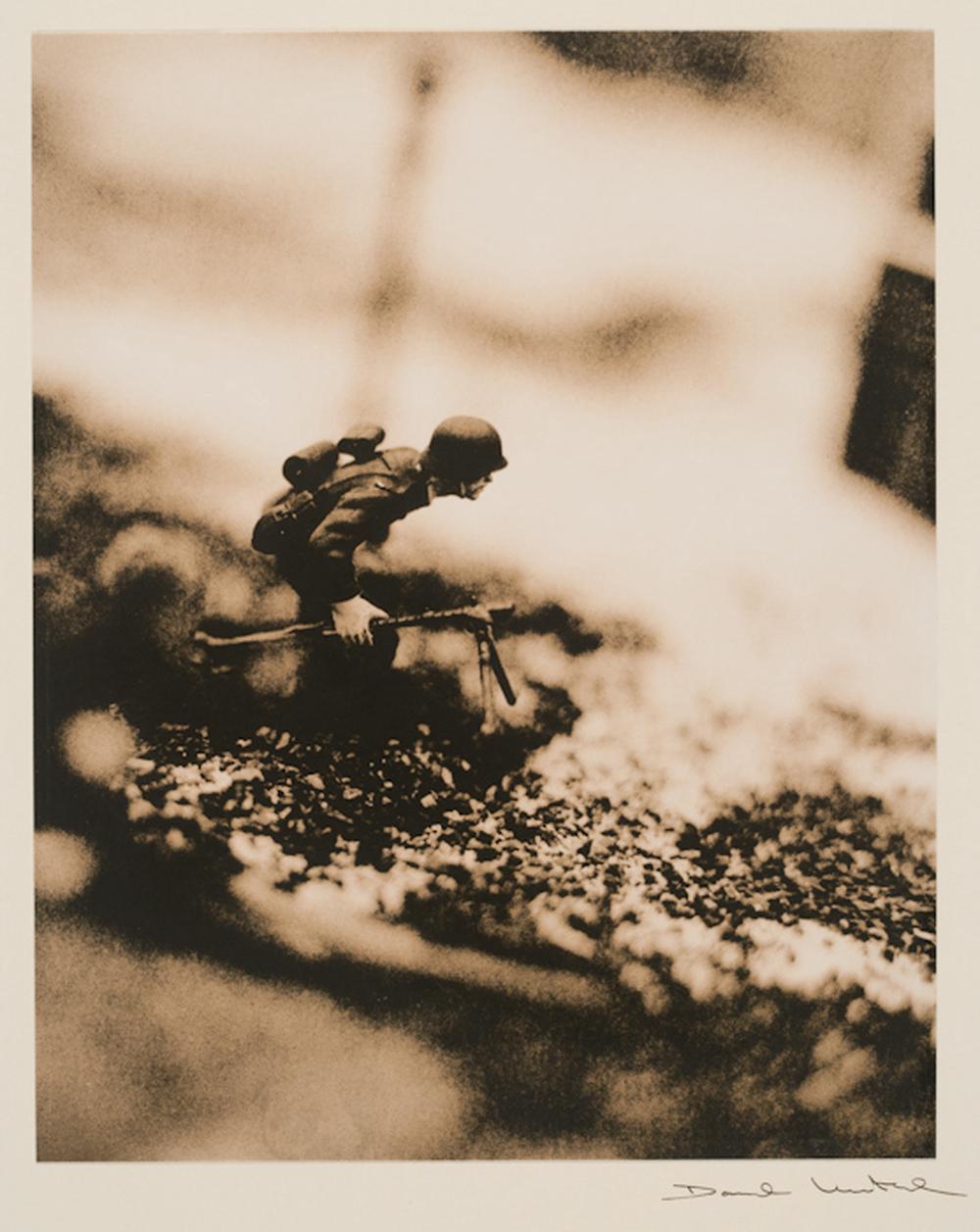 American soldier holding his rifle with his military gear in a muddy-like field