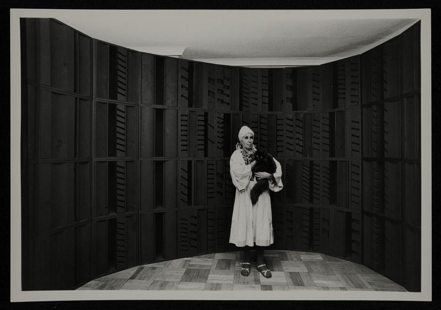 Louise Nevelson in front of a wall sculpture, ca. 1970.